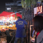 中国の夜市でサトウキビを売る人