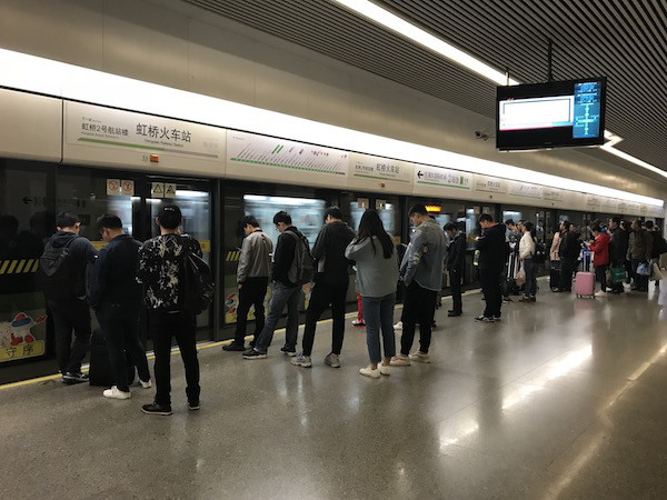 中国の地下鉄駅で列をつくって電車を待つ乗客